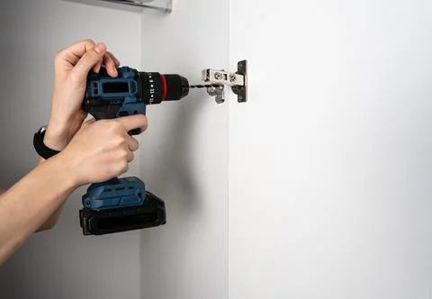 Cordless Drill Tightening Hinge on Wall Stock Photos