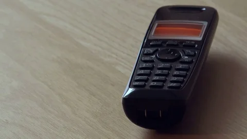 Cordless landline telephone receiver ringing on the table Stock Footage 72139117