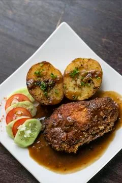 Cordon bleu breaded fried chicken gravy and potatoes meal Stock Photos