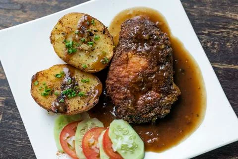 Cordon bleu breaded fried chicken gravy and potatoes meal Stock Photos