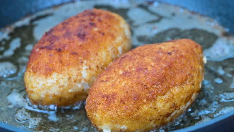 Cordon bleu schnitzels filled with melted cheese frying Vídeo Stock 345583788