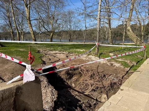 Cordoned off site by river, bare trees, sunny, concept of building safety. Foto stock
