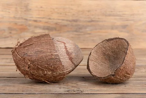 The core of a coconut in a split shell on a wooden background. Foto stock