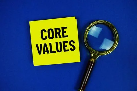 Core Values text on sticky note with magnifying glass on blue background Stock Photos