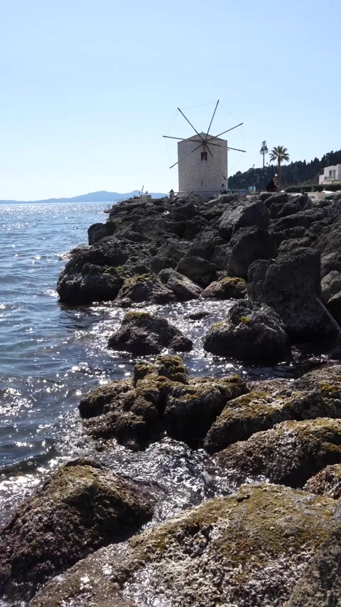 Corfu Greece old Windmill on the Water. Ionian Sea Waves Hitting Rocks on S.. Stock Footage 336595083