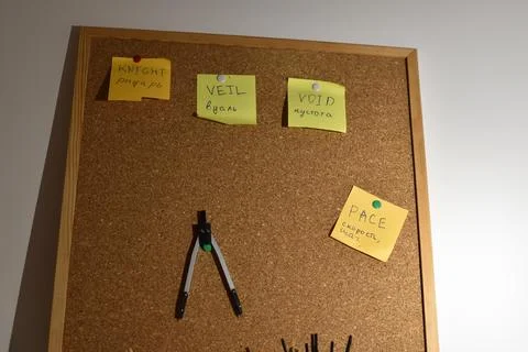 Cork board with yellow sticky notes and compass on wall Foto stock