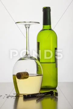 A Cork Floating Inside An Upside-Down Glass Of Wine