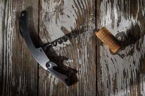 Corkscrew and Cork Resting on Rustic Wooden Surface in Gentle Light Stock Photos