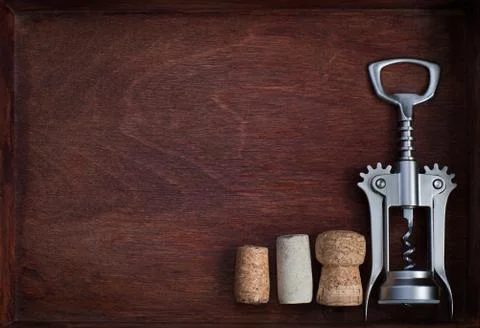 Corkscrew and three wine corks into dark box Stock Photos