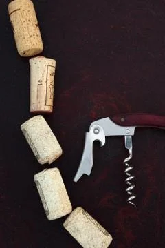 Corkscrew with corks on rusty dark background Stock Photos