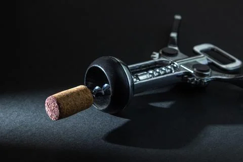 Corkscrew on a dark background. Wine cork on a corkscrew on a black background.  Stock Photos