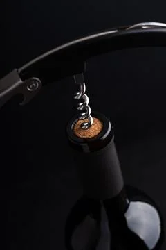 Corkscrew opening a bottle of red wine Stock Photos