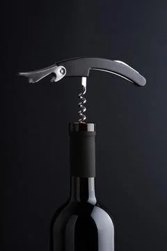 Corkscrew opening a bottle of red wine, starting to pull cork Stock Photos