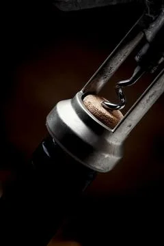 Corkscrew, pulling out the cork from a wine bottle, black background, selecti Stock Photos