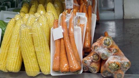 Corn and carrots packaged in plastic are sold in supermarkets or store Stock Photos