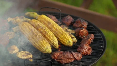 Corn and meat roasted on grill fire Stock Footage 91233372