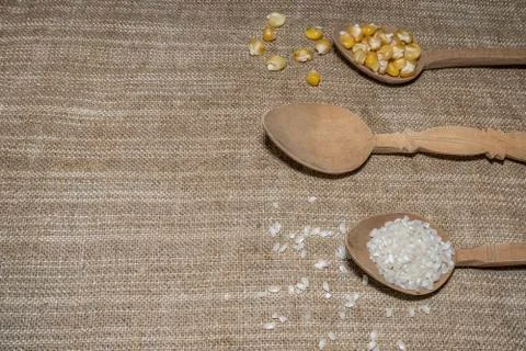 Corn and rice in spoons Stock Photos