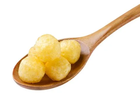 Corn balls in a wooden spoon close-up on a white. Isolated Stock Photos