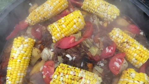 Corn with beef and vegetables. Soup with Tomato, red pepper cooked on hot coals Video stock 218646982