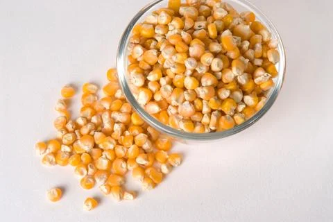 Corn in bowl spread on white background Stock Photos