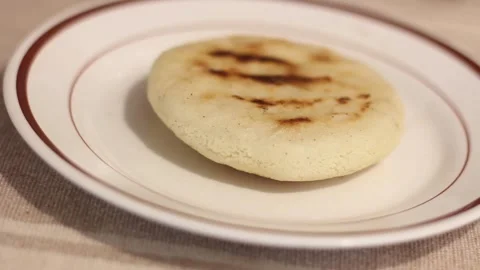 Corn cake or arepa on the surface of a plate. Stock Footage 306079440