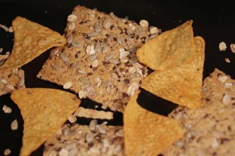 <Corn chips and scones on black background. Stock Photos