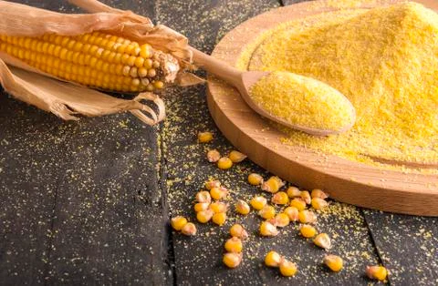 Corn cob and flour spread on table Stock Photos