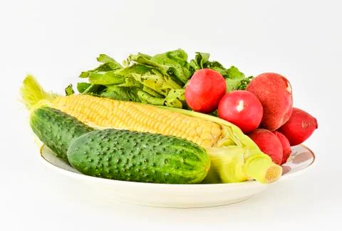 Corn on the cob cucumbers and a head of radishes Foto stock