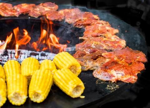 Corn on the cob on the fire ring grilled with open fire deliciously crispy Stock Photos