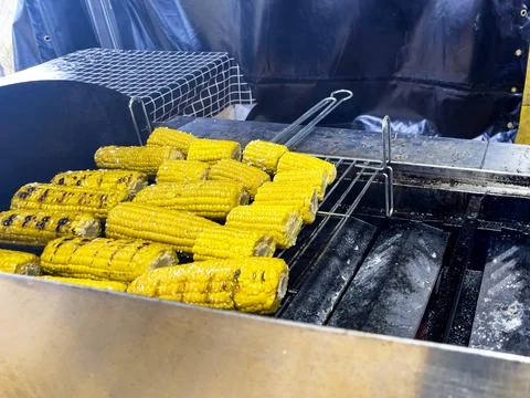 Corn on the cob roasted on a red-hot charcoal barbecue is a delicious dish. Stock Photos