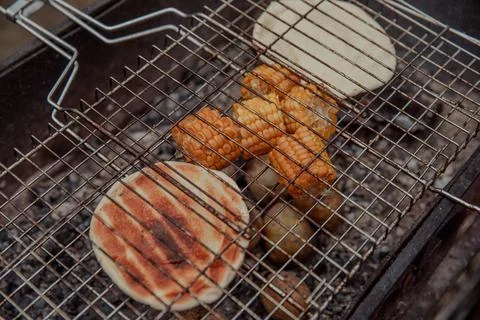 Corn cobs and bread are fried on coals with potatoes at a picnic Stock Photos