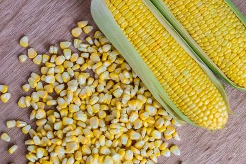 Corn cobs and corn grains on wood background Stock Photos
