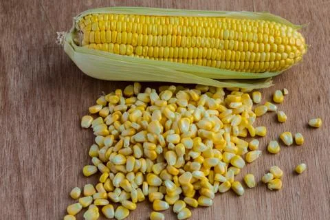 Corn cobs and corn grains on wood background Foto stock