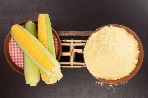 Corn cobs and heap of corn flour. Stock Photos
