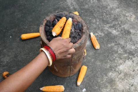 Corn cobs being grilled on a coal stove. Stock Photos