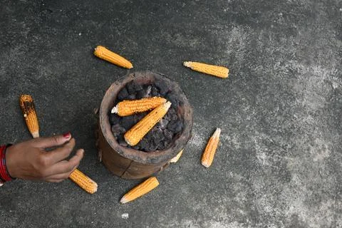 Corn cobs being grilled on a coal stove. Stock Photos
