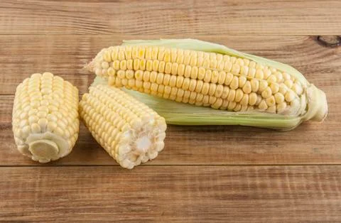 Corn cobs on a wooden table Stock Photos