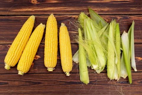 Corn cobs on wooden table. Stock Photos