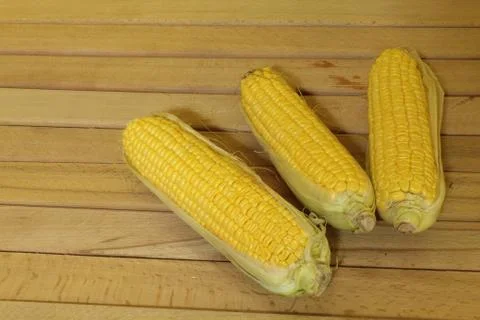 Corn cobs on a wooden table Stock Photos