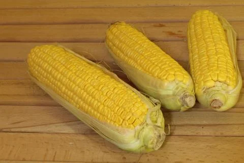 Corn cobs on a wooden table Stock Photos