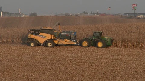 Corn combine unloads corn into tractor drawn trailer, 4K. Stock Footage 101614072
