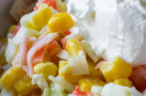 Corn, crab stick, and egg salad with sour cream. Close-up of crab salad. Stock Photos