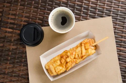 Corn dog in a box next to coffee in a paper cup Stock Photos