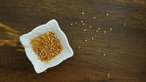 Corn falling on white beautiful bowl, wooden background 스톡 동영상 124203694