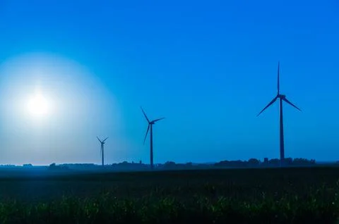 A corn field with large wind turbines against a blue sky at sunset, Dexter, M Stock Photos