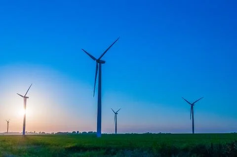 A corn field with large wind turbines against a blue sky at sunset, Dexter, M Stock Photos