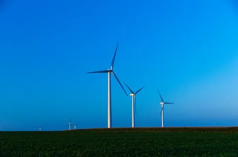 A corn field with large wind turbines against a blue sky at sunset, Dexter, M Stock Photos
