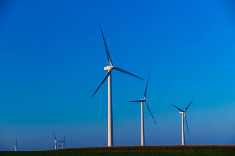 A corn field with large wind turbines against a blue sky at sunset, Dexter, M Stock Photos