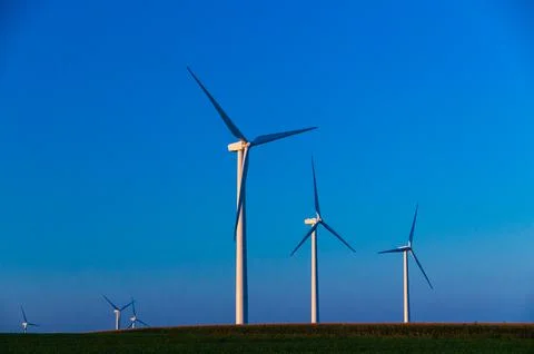 A corn field with large wind turbines against a blue sky at sunset, Dexter, M Stock Photos