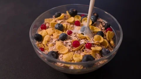 Corn Flakes with blueberry and cranberry pouring with Yogurt Stock Footage 124791271